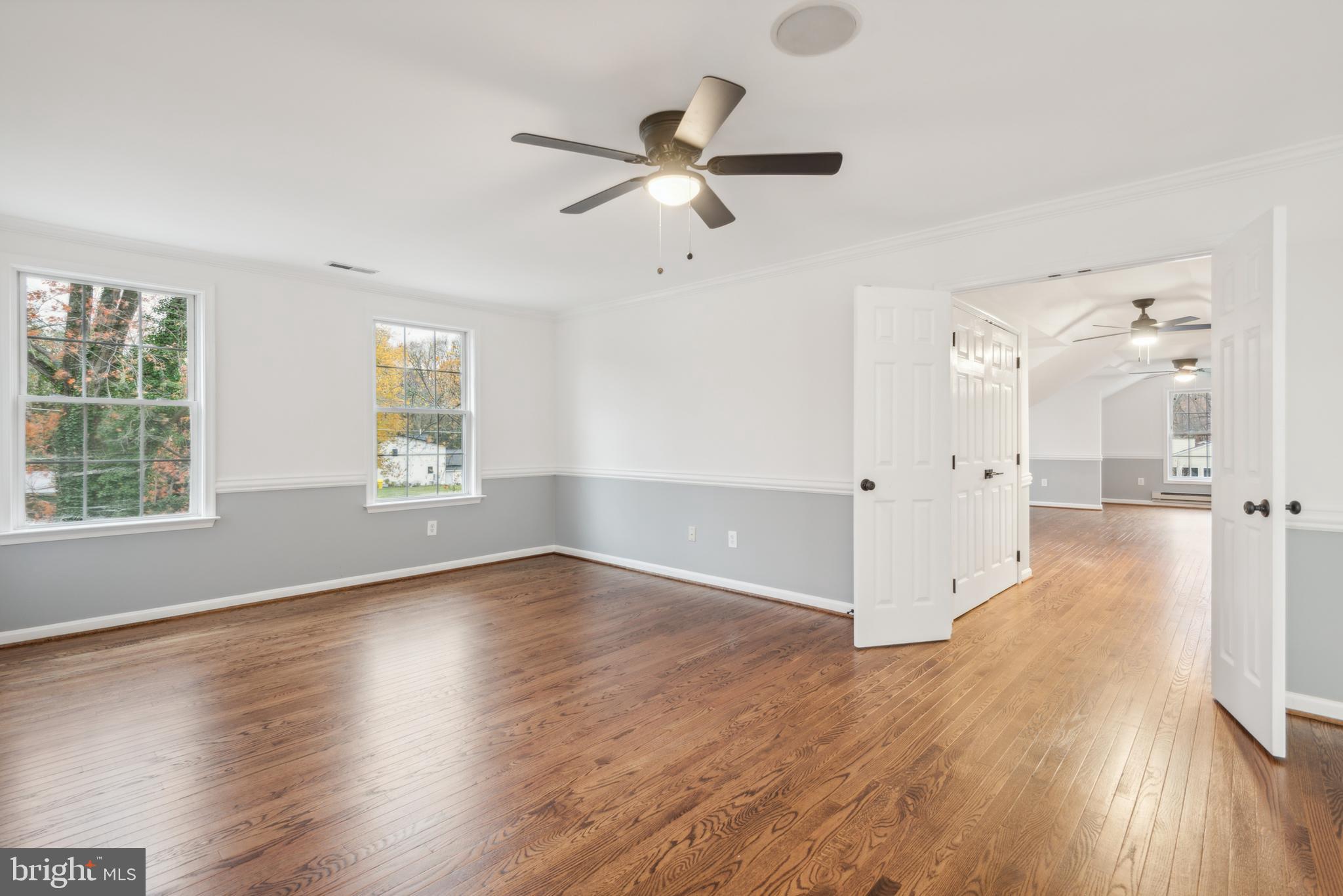 1825 Johnson Road Annapolis, MD 21409 - Photo 19 of 44 an empty room with wooden floor a ceiling fan and windows