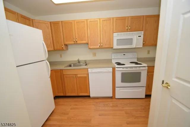 a view of a kitchen with sink and refrigerator