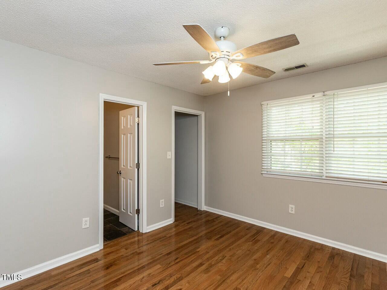 116 Old Maple Lane Durham, NC 27713 - Photo 19 of 30 a view of an empty room with wooden floor and a window