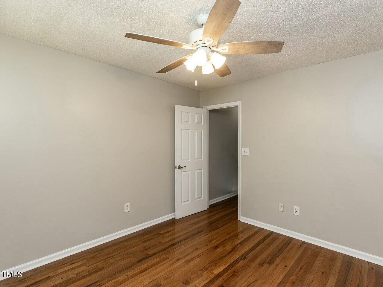 116 Old Maple Lane Durham, NC 27713 - Photo 21 of 30 a view of an empty room with wooden floor and a ceiling fan