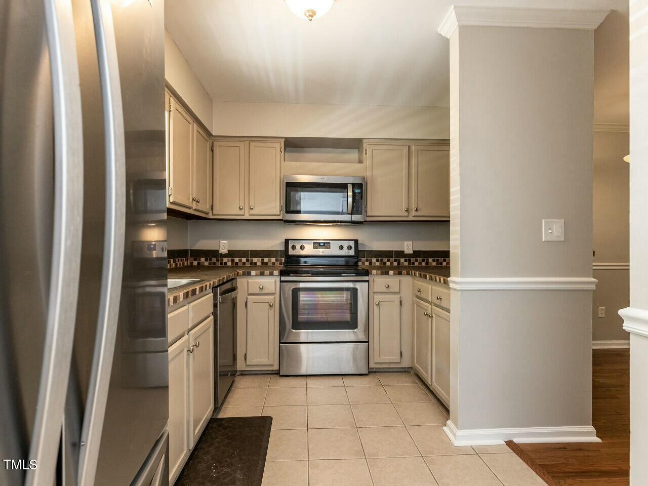 116 Old Maple Lane Durham, NC 27713 - Photo 5 of 30 a kitchen with a stove top oven and cabinets