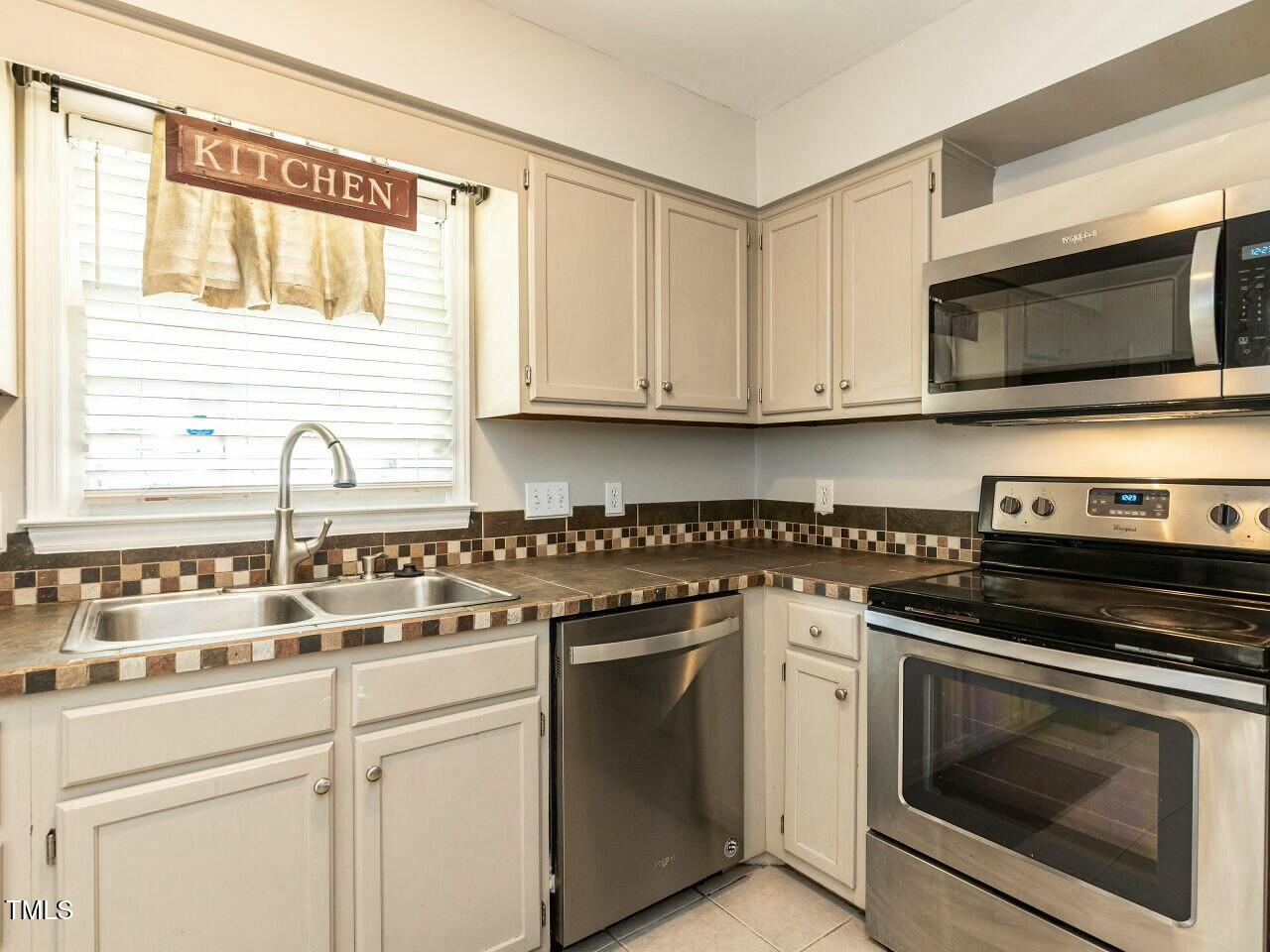 116 Old Maple Lane Durham, NC 27713 - Photo 6 of 30 a kitchen with white cabinets and appliances