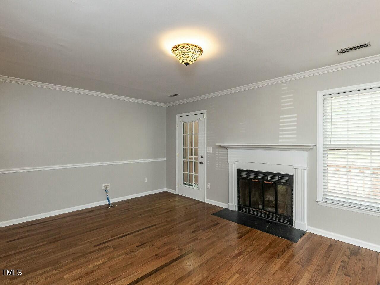 116 Old Maple Lane Durham, NC 27713 - Photo 8 of 30 a view of empty room with wooden floor and fireplace
