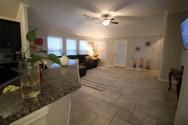 a living room with granite countertop couches a fireplace and a flat screen tv