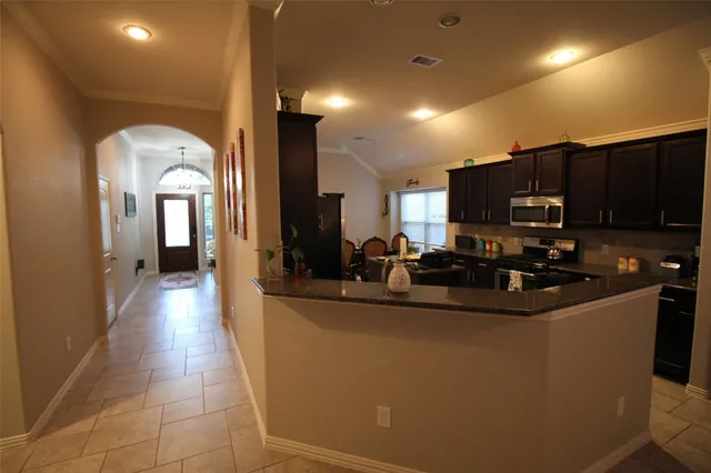 a kitchen with kitchen island granite countertop a sink a stove and cabinets