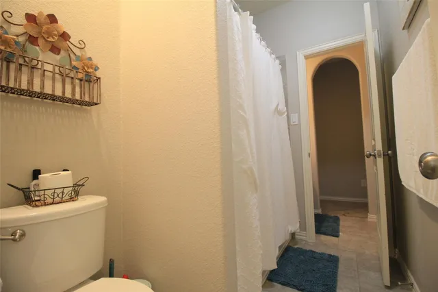 a bathroom with a toilet and a shower