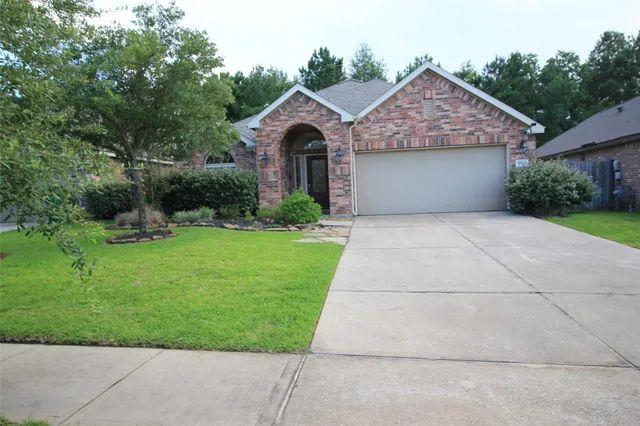 a front view of a house with yard and green space