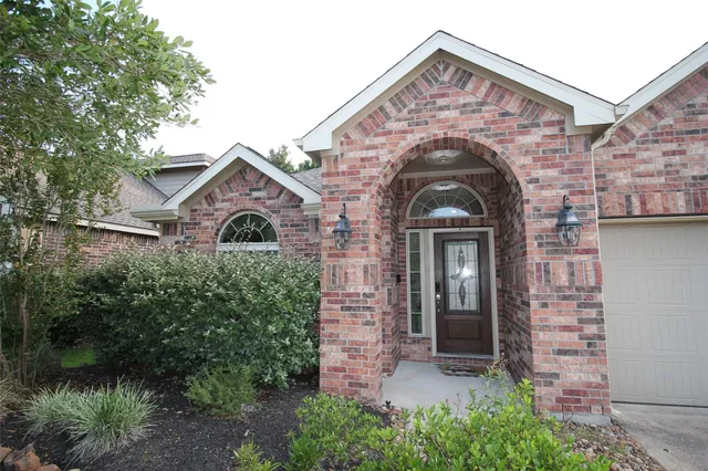 a view of a house with a small yard and a large tree