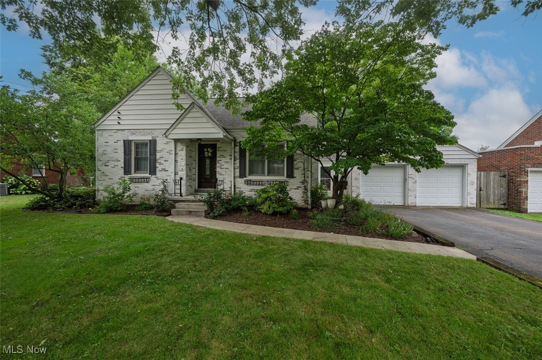 Front of home with 2 car attached garage and paved walkway to front entrance