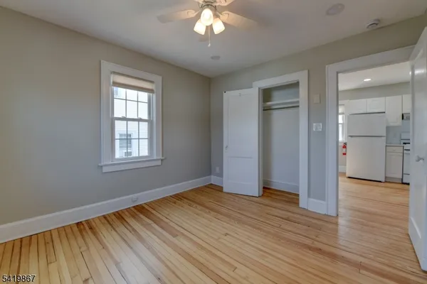 a view of an empty room with window and wooden floor