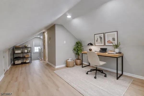 a view of a hallway with wooden floor and a window