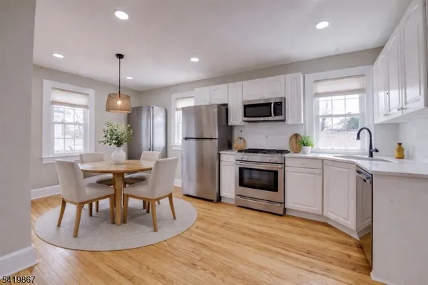 a kitchen with a table chairs microwave and refrigerator