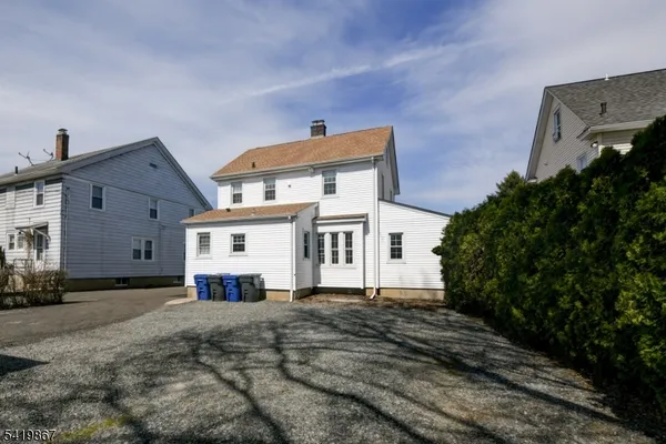 a wooden house with a large tree in front of it