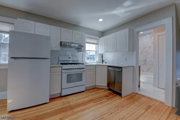 a view of kitchen with wooden floor electronic appliances and window