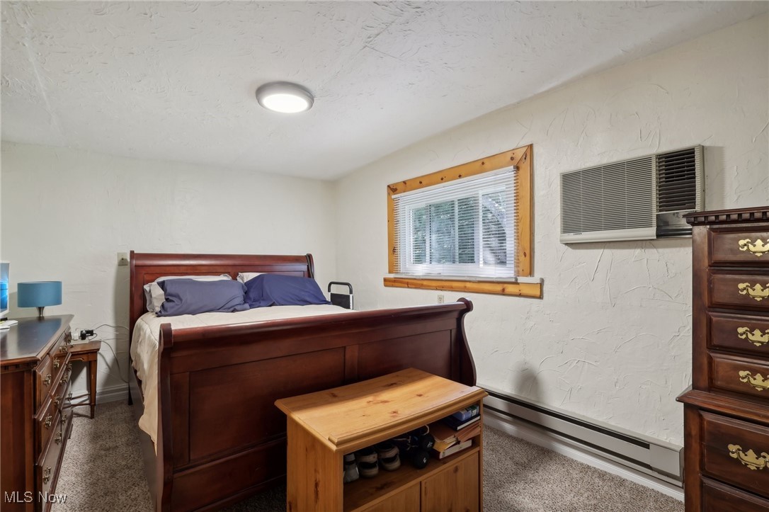 6672 Ross Road Madison, OH 44057 - Photo 47 of 50 Carpeted bedroom with baseboard heating and a wall unit AC