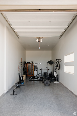 629 Spring Lily Drive St. George, UT 84790 - Photo 44 of 50 Spacious garage interior featuring a high ceiling, white painted walls, and an epoxy flake flooring system