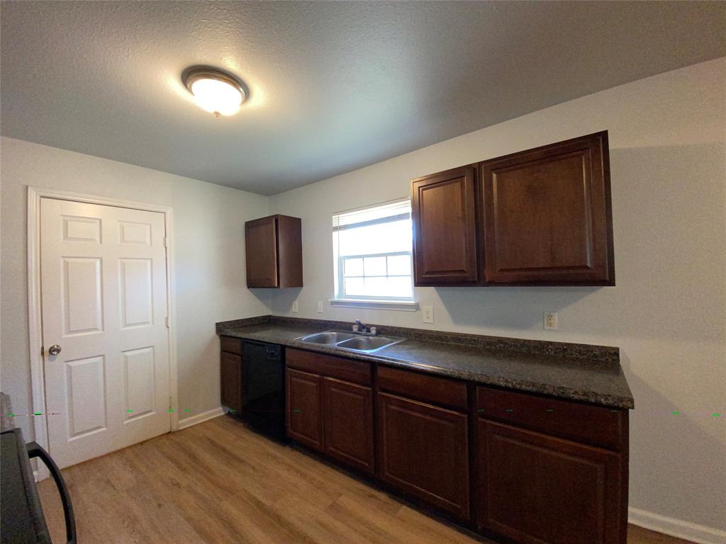 6928 Alexandria Court Fort Worth, TX 76133 - Photo 11 of 28 a kitchen with granite countertop wooden cabinets and a sink