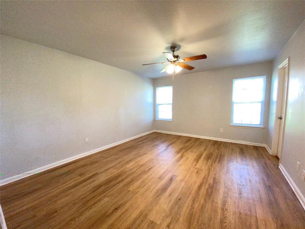6928 Alexandria Court Fort Worth, TX 76133 - Photo 19 of 28 wooden floor in an empty room with a window