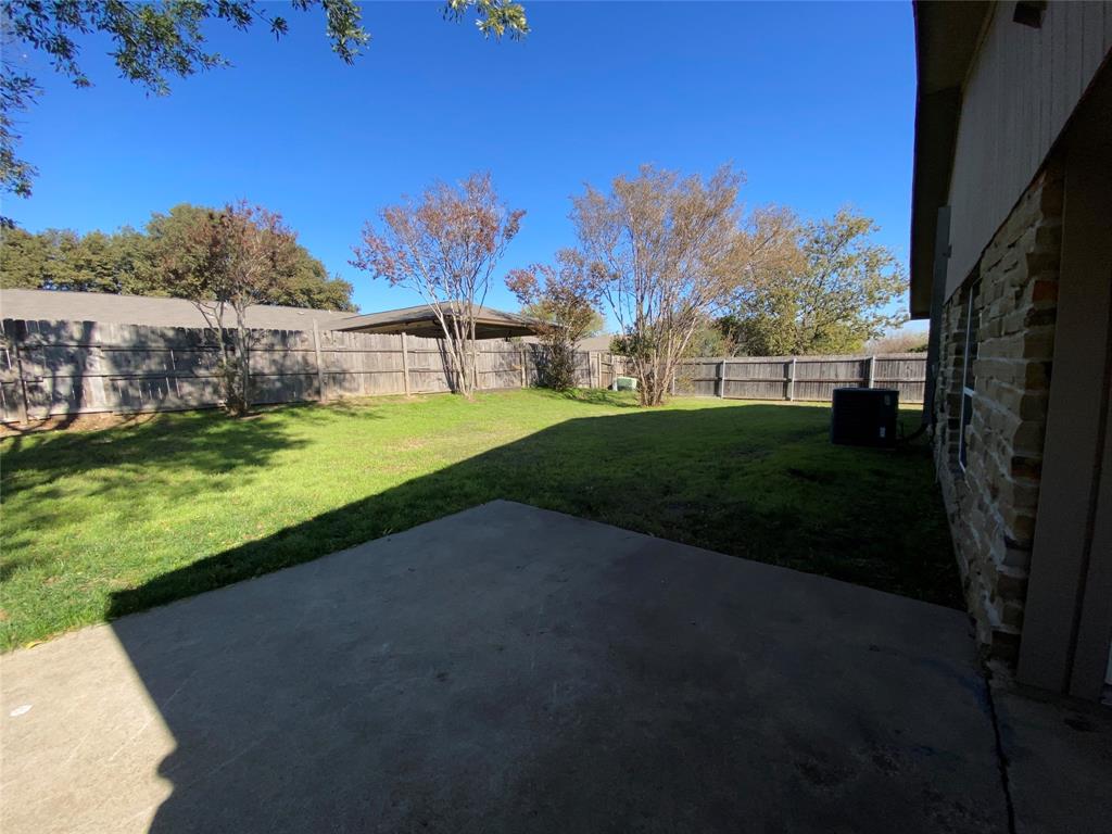 6928 Alexandria Court Fort Worth, TX 76133 - Photo 25 of 28 a view of a yard with an house and a yard