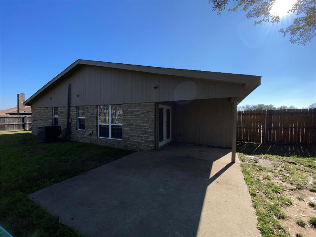 6928 Alexandria Court Fort Worth, TX 76133 - Photo 27 of 28 a backyard of a house with wooden fence