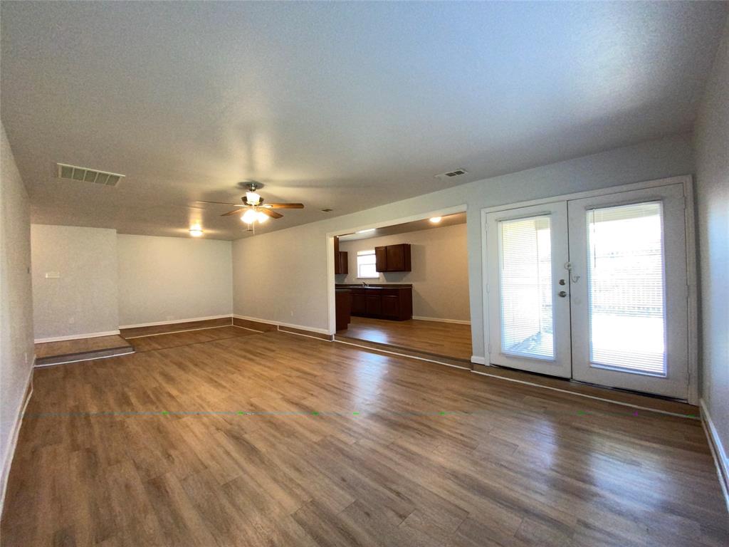 6928 Alexandria Court Fort Worth, TX 76133 - Photo 6 of 28 an empty room with wooden floor and windows