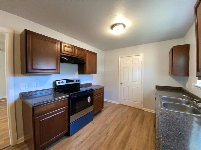 a kitchen with granite countertop wooden cabinets and a sink