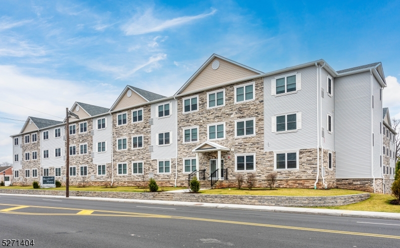 1025 Raritan Road, Unit 303 Clark, NJ 07066 - Photo 2 of 21 a view of a big house with a big yard and large trees