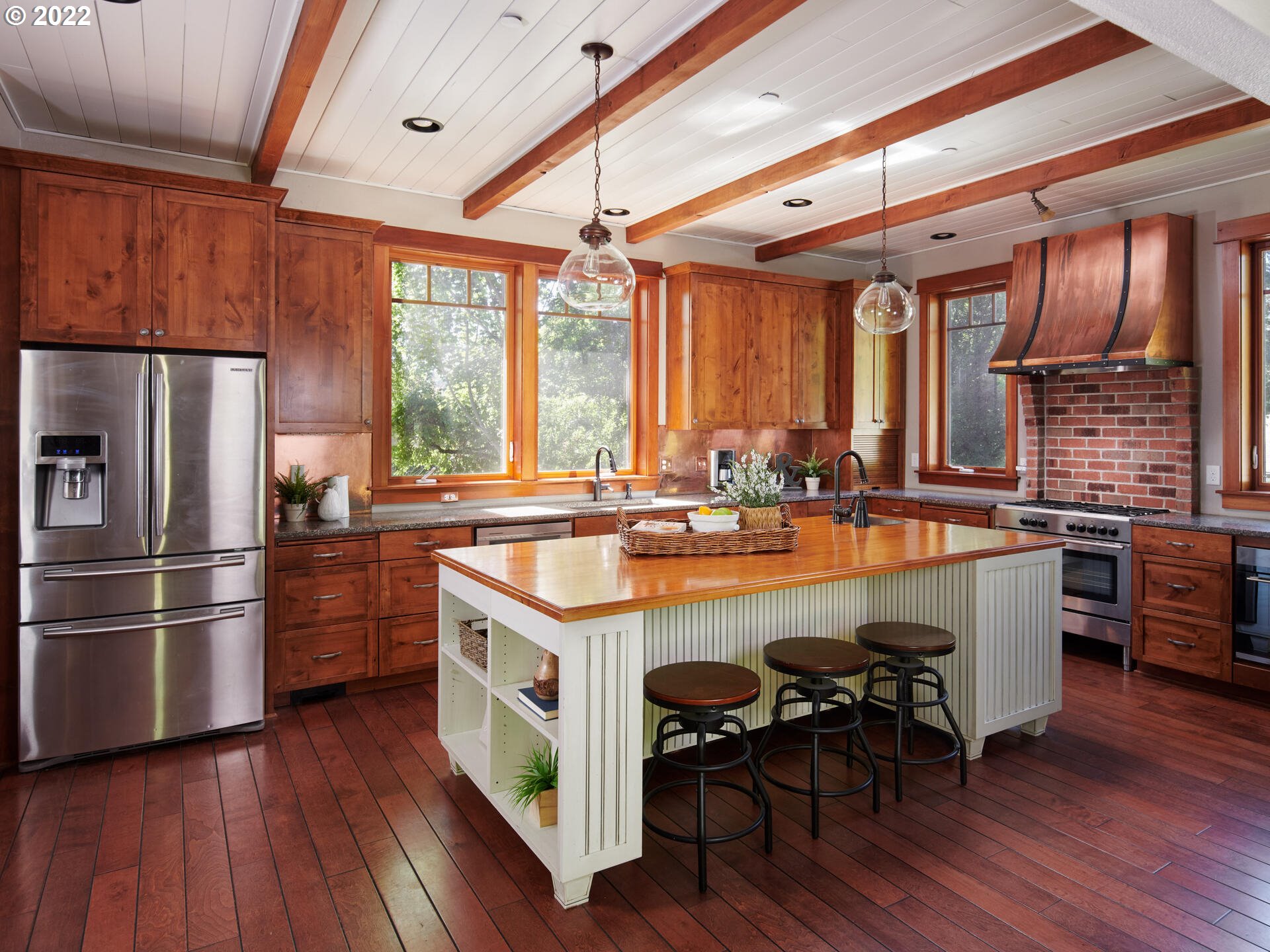 4825 Southwest Evans Street Portland, OR 97219 - Photo 11 of 32 a kitchen with kitchen island granite countertop wooden floors and stainless steel appliances