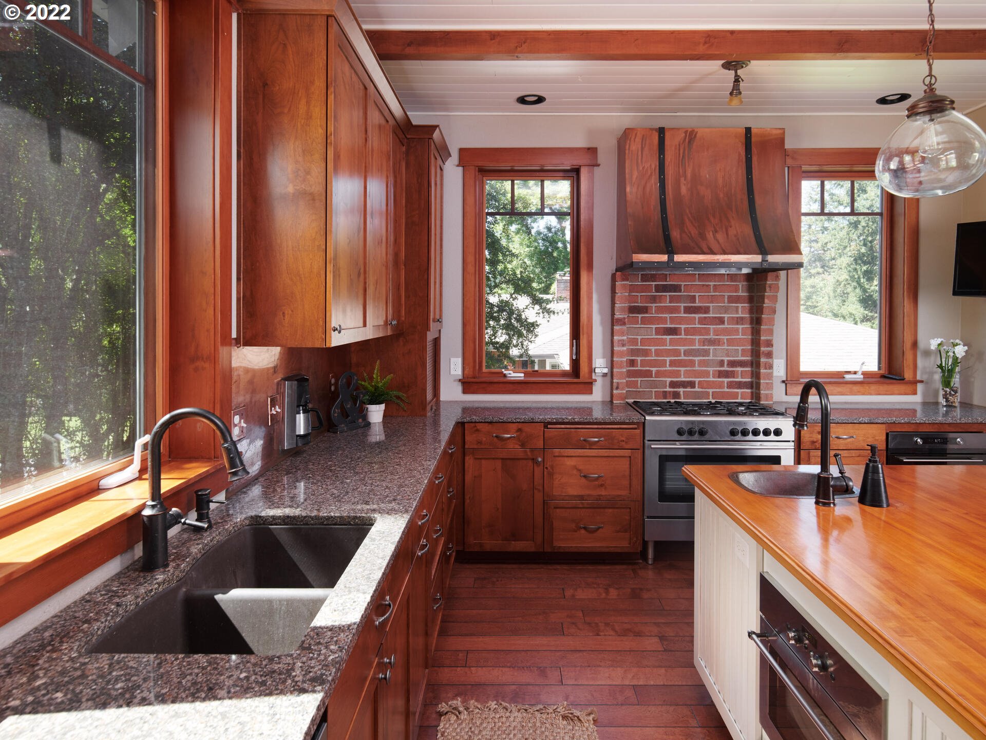 4825 Southwest Evans Street Portland, OR 97219 - Photo 12 of 32 a kitchen with wooden cabinets and a sink