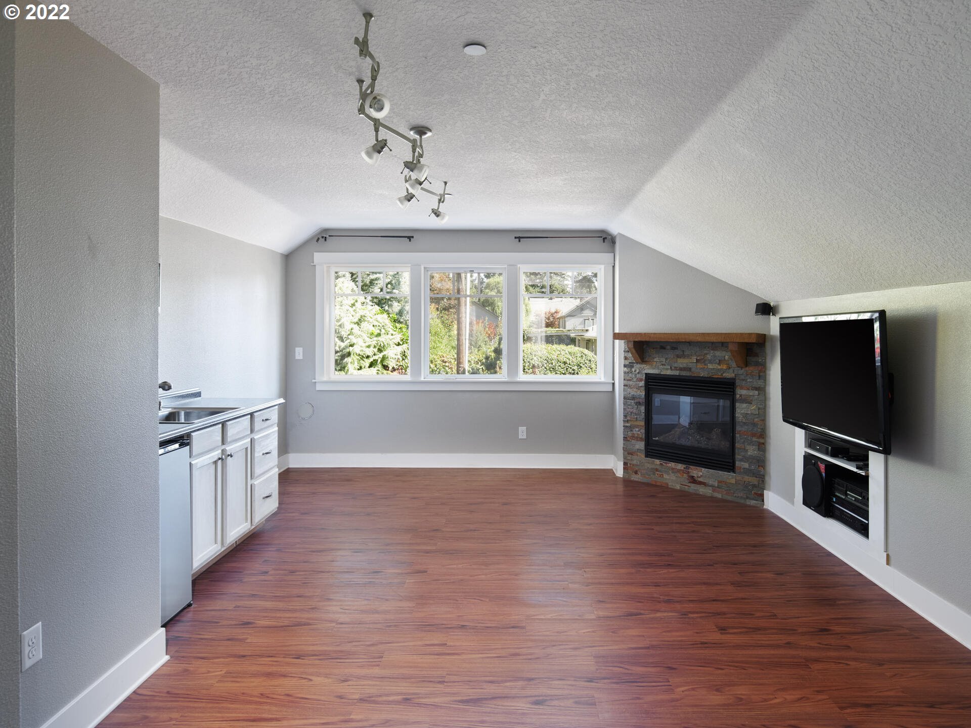 4825 Southwest Evans Street Portland, OR 97219 - Photo 18 of 32 wooden floor in an empty room with a fireplace