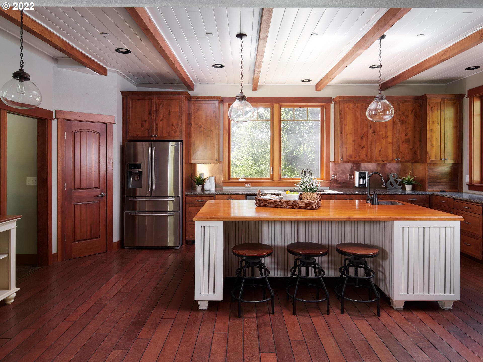 4825 Southwest Evans Street Portland, OR 97219 - Photo 10 of 32 a dining hall with stainless steel appliances granite countertop a refrigerator a sink dishwasher a dining table and chairs with wooden floor