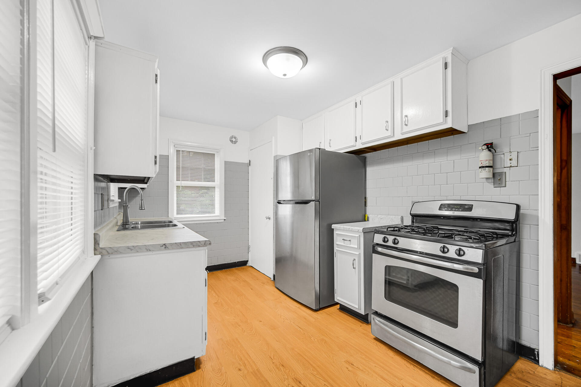 4641 Delaware Street Gary, IN 46409 - Photo 11 of 22 a kitchen with stainless steel appliances a stove a refrigerator and cabinets