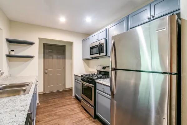 a kitchen with stainless steel appliances a refrigerator stove and microwave