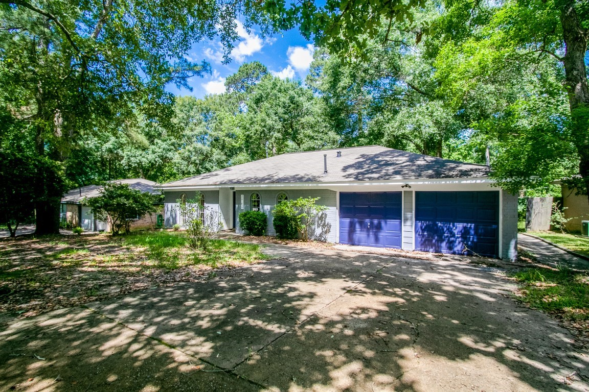 24615 Wilderness Road Spring, TX 77380 - Photo 2 of 34 a front view of a house with a garden