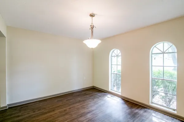 a view of empty room with wooden floor and window