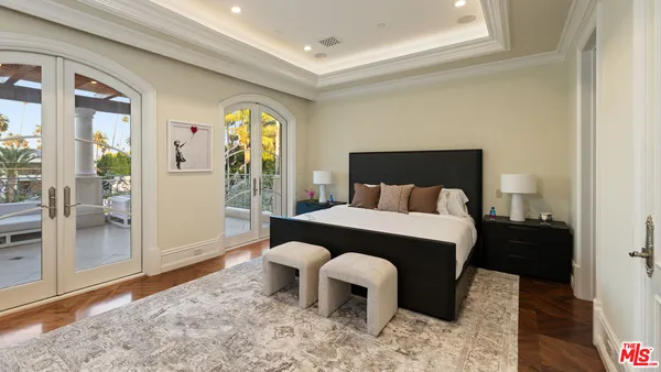 a bedroom with a bed and a flat tv screen on dresser