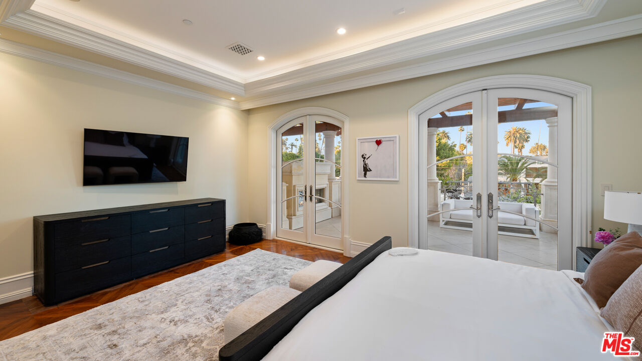 718 North Rodeo Drive Beverly Hills, CA 90210 - Photo 28 of 51 a bedroom with a bed and a flat tv screen on dresser