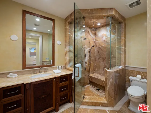 a bathroom with a granite countertop sink a toilet and shower