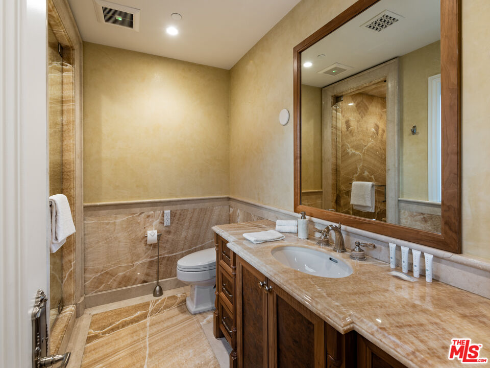718 North Rodeo Drive Beverly Hills, CA 90210 - Photo 44 of 51 a bathroom with a granite countertop sink a toilet and shower