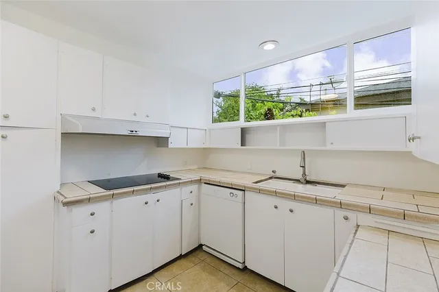 a kitchen with a sink cabinets and window
