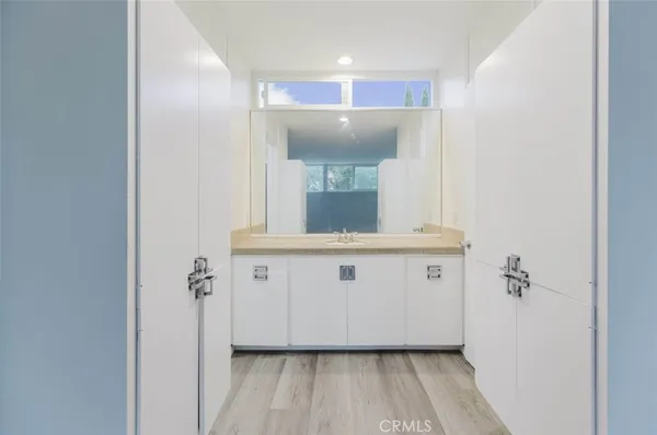 a view of bathroom with a sink mirror and window