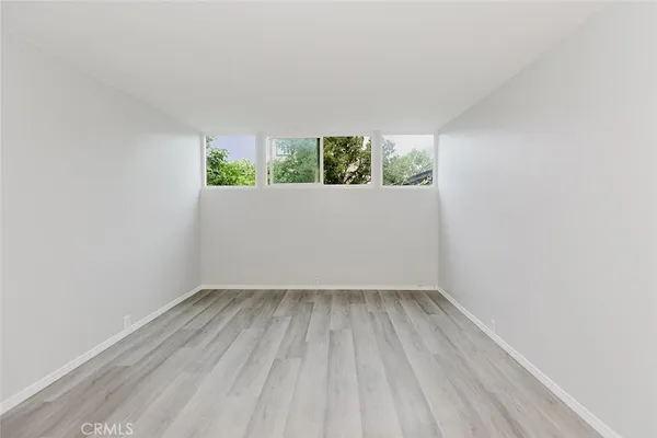 a view of room with window and wooden floor