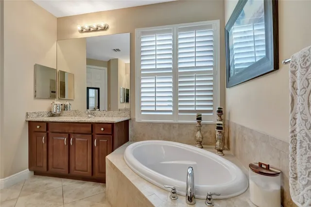 a bathroom with a tub sink and mirror