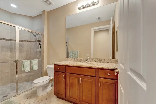 a bathroom with a granite countertop sink toilet a mirror and shower