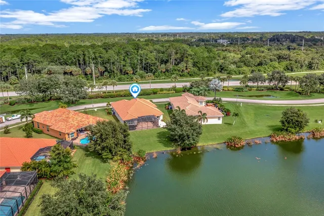 an aerial view of residential houses with outdoor space and lake view