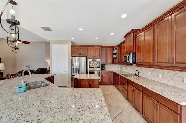 a large kitchen with stainless steel appliances granite countertop a sink and cabinets