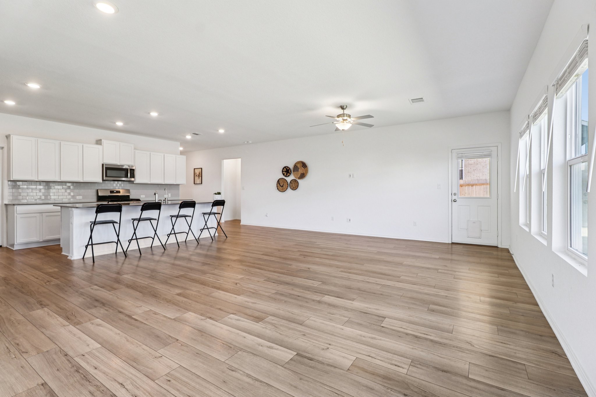 1201 Mallow Road Leander, TX 78641 - Photo 40 of 40 Kitchen featuring an island with sink, white cabinets, open floor plan, a ceiling fan, and stainless steel appliances