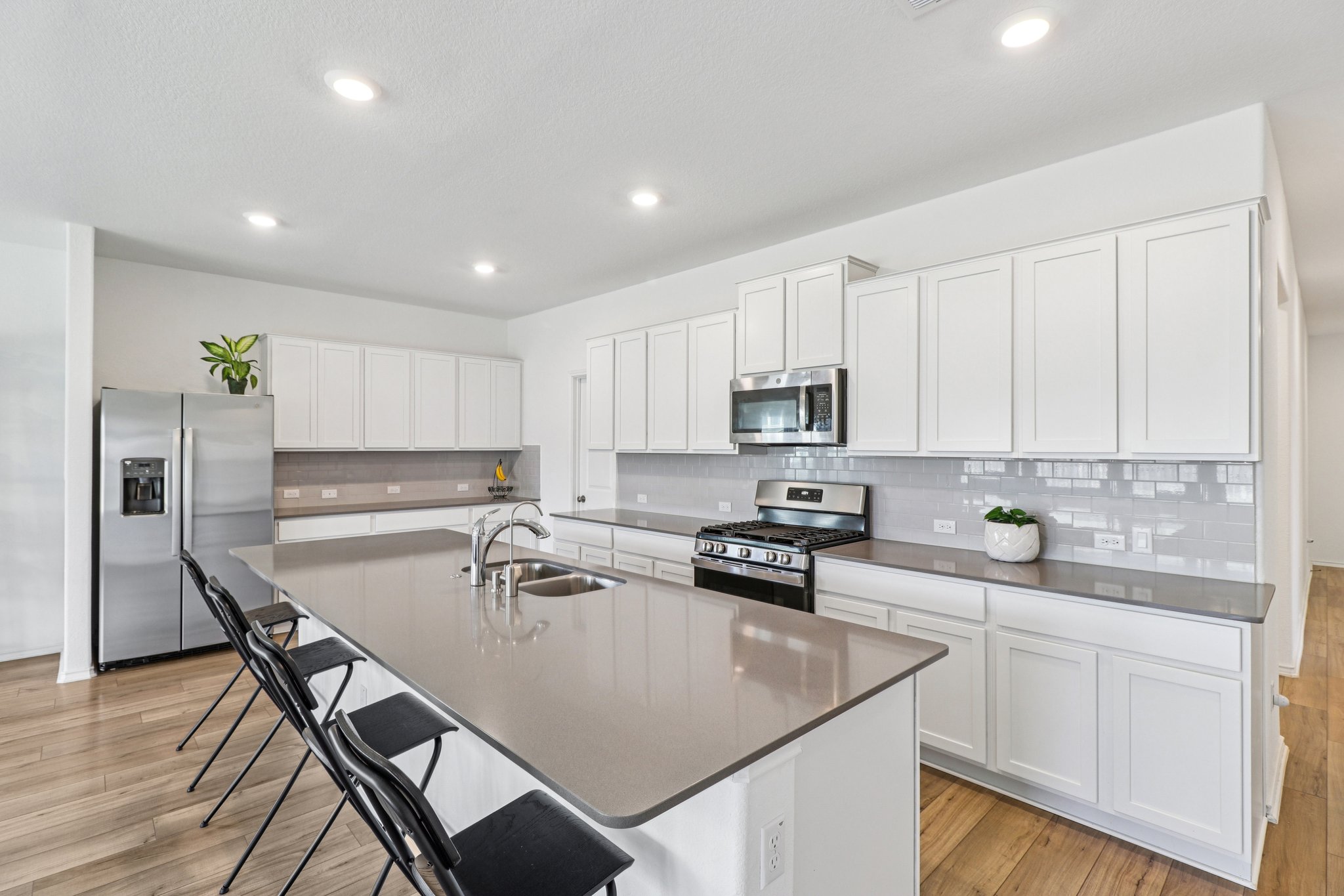 1201 Mallow Road Leander, TX 78641 - Photo 13 of 40 Kitchen with stainless steel appliances, a breakfast bar area, white cabinets, and recessed lighting