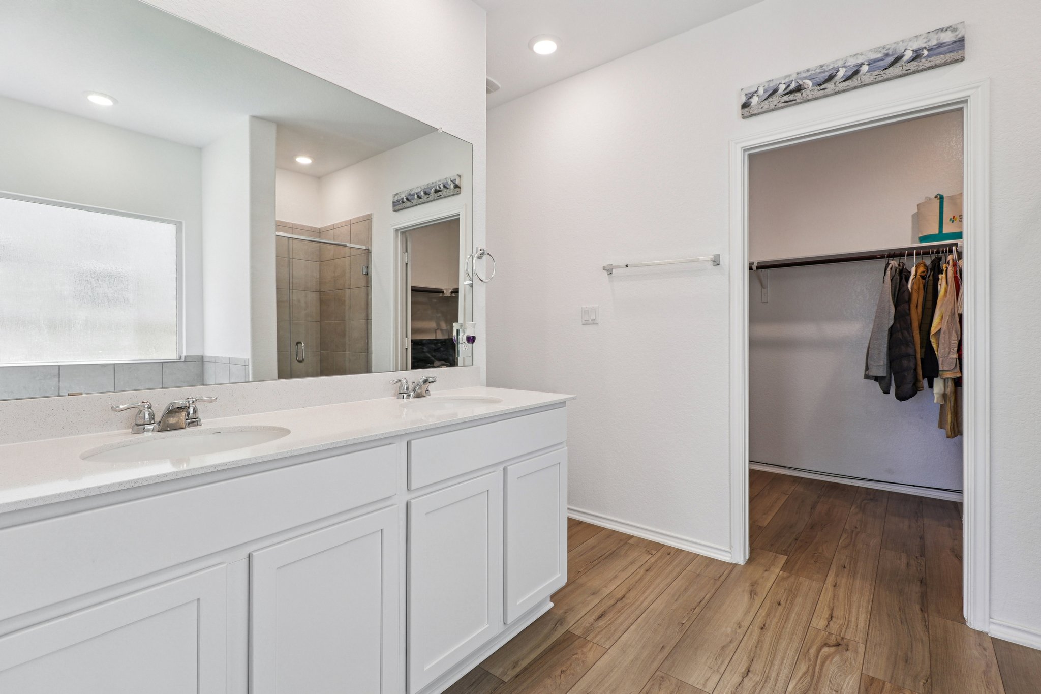 1201 Mallow Road Leander, TX 78641 - Photo 22 of 40 Bathroom with a walk in closet, a stall shower, double vanity, light wood-style floors, and recessed lighting