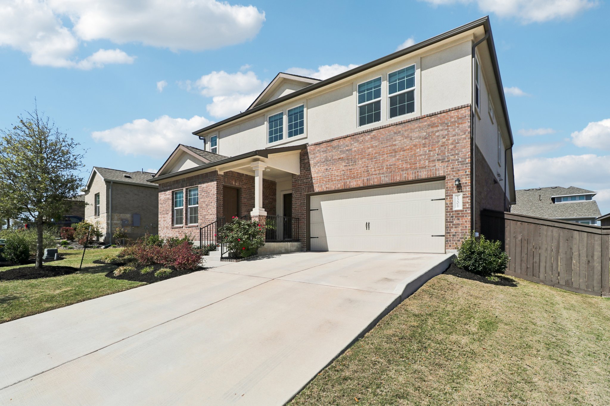 1201 Mallow Road Leander, TX 78641 - Photo 3 of 40 View of front of house featuring a garage, driveway, stucco siding, brick siding, and a porch